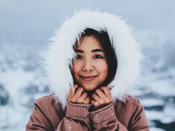 Portrait of smiling young woman in warm cloths during winter