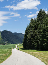 Man riding motorcycle on road against sky
