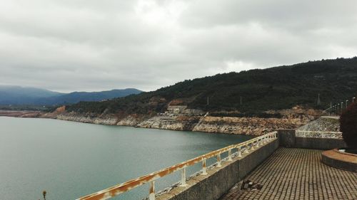 Scenic view of river by mountains against sky