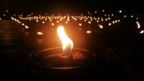 Close-up of lit candles in the dark