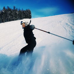 Man skiing in snow against sky