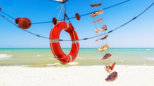 Fishing net on beach against clear sky