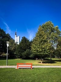 Bench in park against sky
