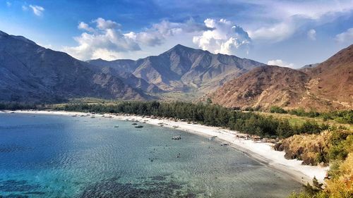 Scenic view of river by mountains against sky