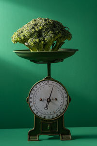 Close-up of broccoli on table against wall