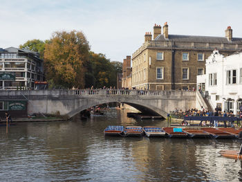 Bridge over river in city against sky