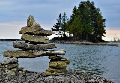 Stack of stones on rock against sky