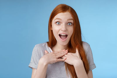 Surprised woman against blue background