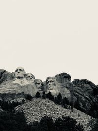 Low angle view of statue on mountain against sky