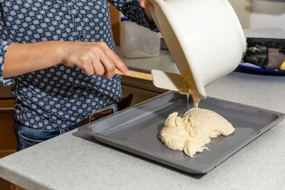 Midsection of woman holding ice cream on cutting board