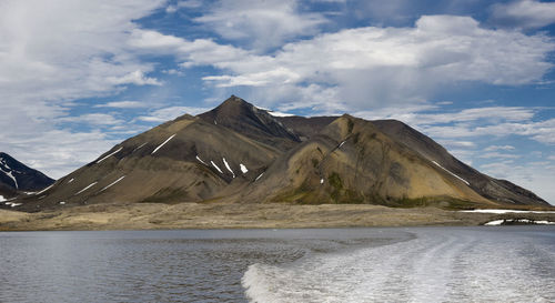 Scenic view of mountains against cloudy sky