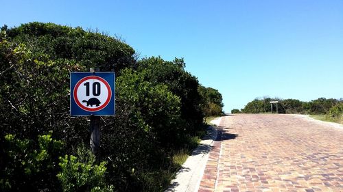 Road sign against blue sky