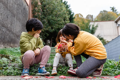 Two elder sisters helping to clean the face of younger sister