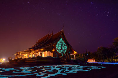 Illuminated building against sky at night