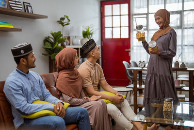 Smiling woman serving dessert to guests at home