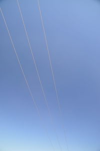 Low angle view of cables against clear blue sky