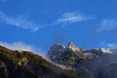 Scenic view of snowcapped mountains against blue sky