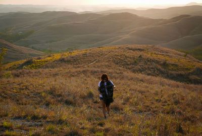 High angle view of woman walking on field against mountains