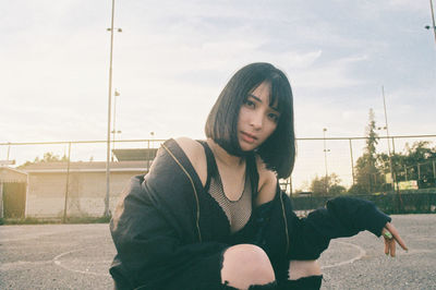 Portrait of woman crouching at basketball court