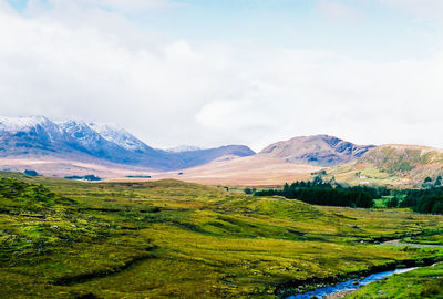 Scenic view of mountains against cloudy sky