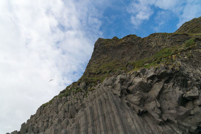 Low angle view of mountain against cloudy sky