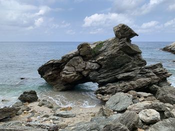 Rocks on sea shore against sky