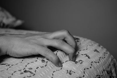 Cropped hand of woman on bed