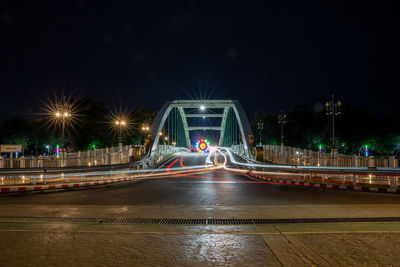 Bridge with light trail of cars illuminated city at night
