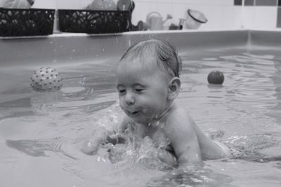 Close-up of shirtless baby girl swimming in pool