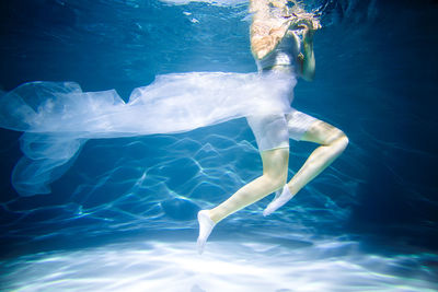 Low section of woman swimming in pool