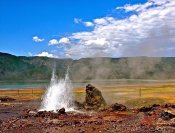 Water splashing on land against sky