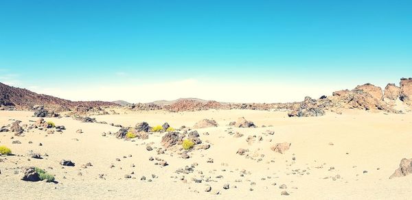 Scenic view of desert against clear blue sky