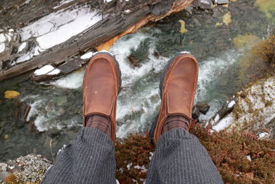 Low section of person standing by water