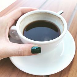 Close-up of hand holding coffee cup