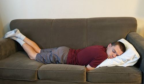 Young woman sitting on sofa at home