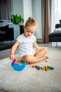 Boy playing with toy blocks at home