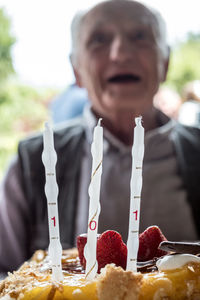 Senior man by birthday cake