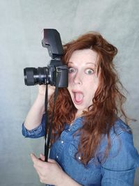 Portrait of young woman with camera