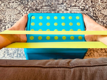 Close-up of hand holding yellow wall