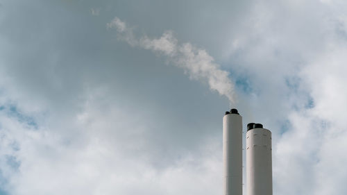 Low angle view of smoke emitting from chimney against sky