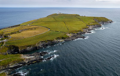 Drone aerial of galley head lighthouse. dundeady headland island cork county ireland