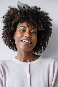 Beautiful black woman with afro hair smiling on the white background
