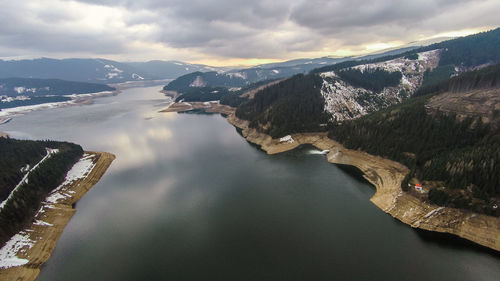 Aerial view of lake amidst mountains against sky