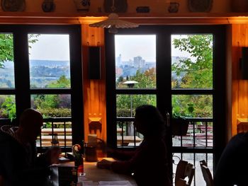 People sitting at restaurant seen through window