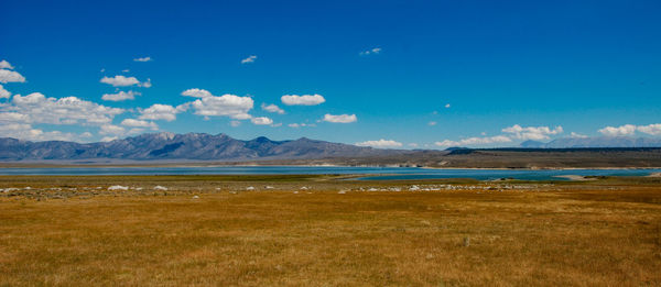 Scenic view of lake and mountains against blue sky