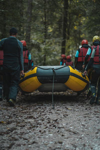 Rear view of people relaxing in forest