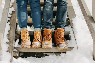 Low section of couple standing on steps during winter