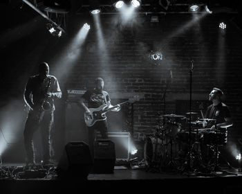 View of people playing guitar at music concert