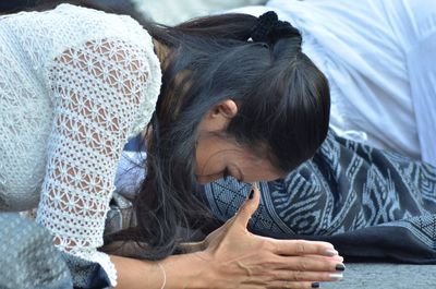 Woman praying on street during performance