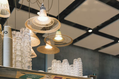 Low angle view of illuminated pendant lights over glass